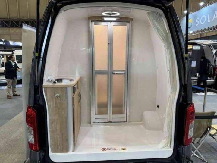 Задняя часть кемпервэна на базе Nissan Caravan отведена под душ, который можно принимать на…