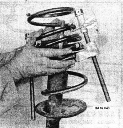 Снимите приспособление, сжимающее пружину, вместе с пружиной.