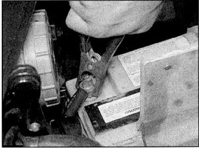 2. Свържете другата клема на червения стартов кабел към положителния полюс на допълнителната…