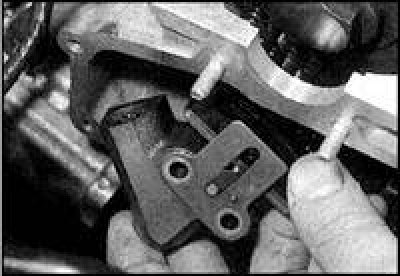 4. На автомобилях ранних выпусков отверните болты и снимите направляющую планки верхней цепи.