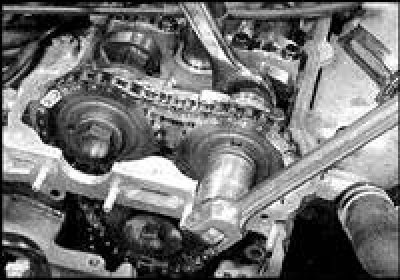 6. На двигателях более поздних выпусков отведите башмак натяжителя от верхней цепи и зафиксируйте,…