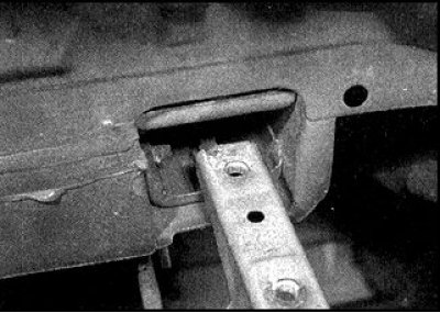 3. Працуючы ў багажніку, падніміце кілімкі, дастаньце заглушкі (фота злева) і адкруці па 2 ніта…